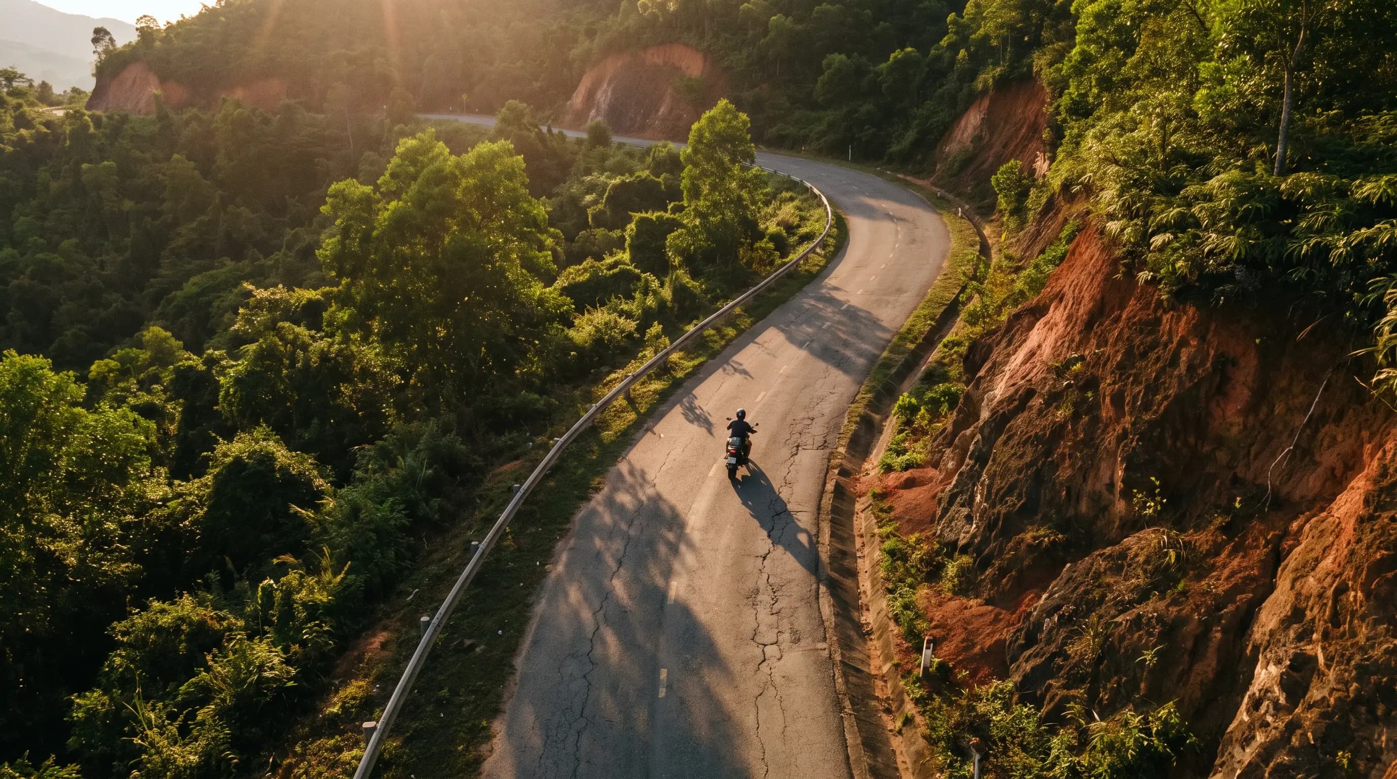 Aerial view of a motorcycle on a jungle mountain pass