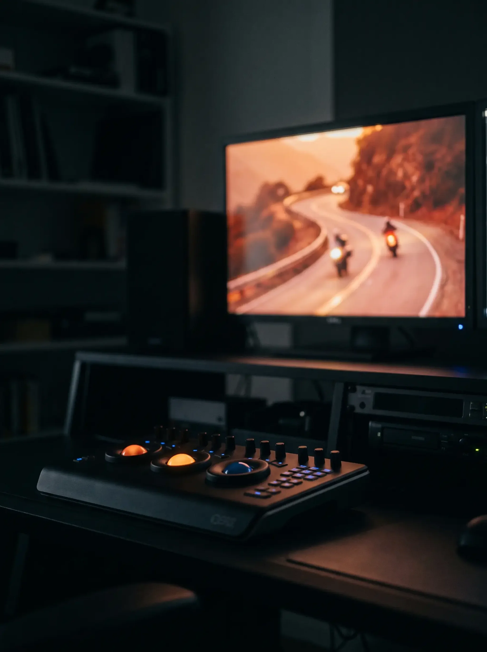 Colour grading desk in a daylit room, control panel and a motorcycle shot on the monitor